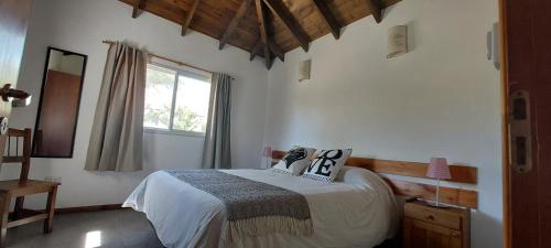 a bedroom with a bed and a window at Casa Condal in Villa General Belgrano
