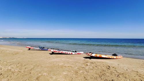 três barcos sentados na praia perto da água em DOMUS RESIDENCE - CATULLO - em Bari