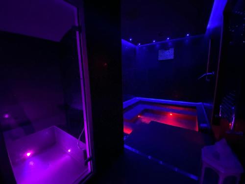 a dark room with purple and red lights at White albergo diffuso Ristorante & SPA in Foggia