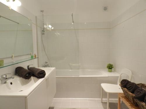 baño blanco con bañera, lavamanos y bañera tubermott en Apartment St-Anna, en Brujas