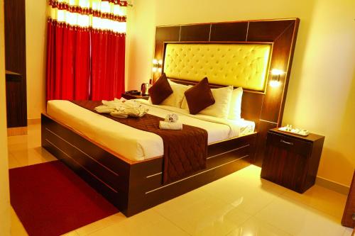 a bedroom with a large bed with a red curtain at SS Silver Oaks Resort in Yercaud