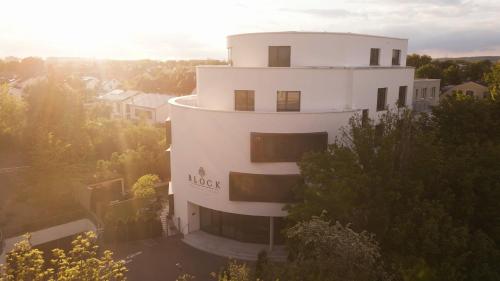 un grand bâtiment blanc avec le soleil en arrière-plan dans l'établissement BLOCK Hotel & Living, à Ingolstadt