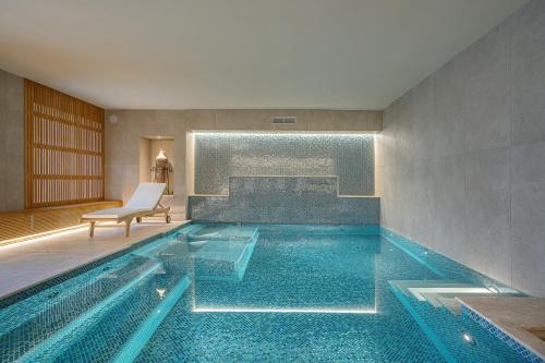 a swimming pool in a room with a chair at Hotel Mary in Vico Equense