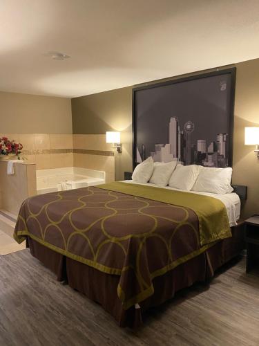 特勒爾的住宿－Super 8 by Wyndham Terrell，酒店客房设有一张大床和浴缸。