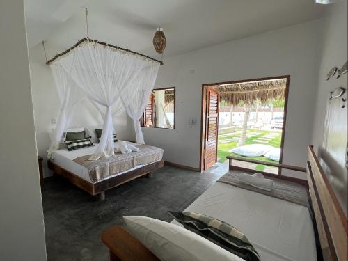 1 dormitorio con 2 camas y ventana en Vila Bless 4 bedroom Vila with pool, garden and beach tennis court, en Prea