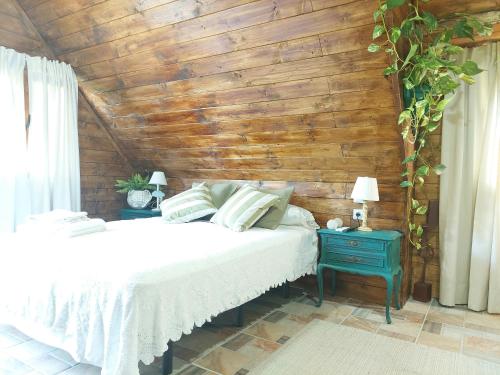 a bedroom with a white bed and a wooden wall at Casa Solis Monteprincipe in Boadilla del Monte