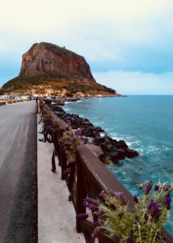 a road next to the ocean with a mountain at Ritsos Family Apartment in Monemvasia