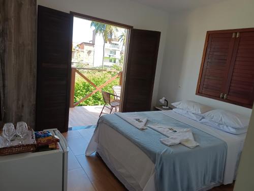 a bedroom with a bed and a large window at Pousada Vila dos Santos in Porto De Galinhas