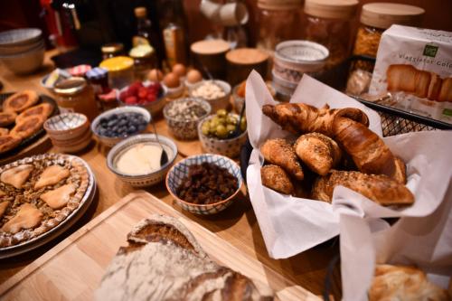 a table with many different types of breads and other foods at Boutique B&B and Wellness la Casa dei 5 Elementi in Giubiasco
