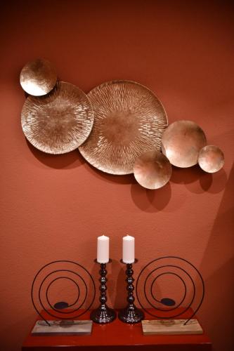 a wall with three plates and two candles on a wall at Boutique B&B and Wellness la Casa dei 5 Elementi in Giubiasco