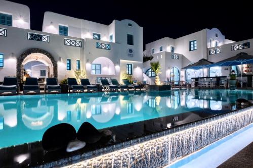 a swimming pool in front of a building at night at Anastasia Princess Luxury Residence - Adults Only in Perissa