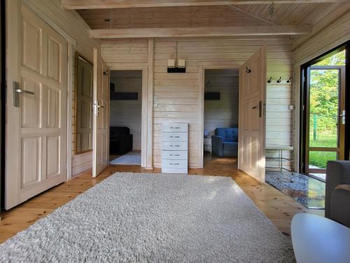 ein Wohnzimmer mit einer Tür und einem Teppich in der Unterkunft Domek 105 in Gietrzwałd