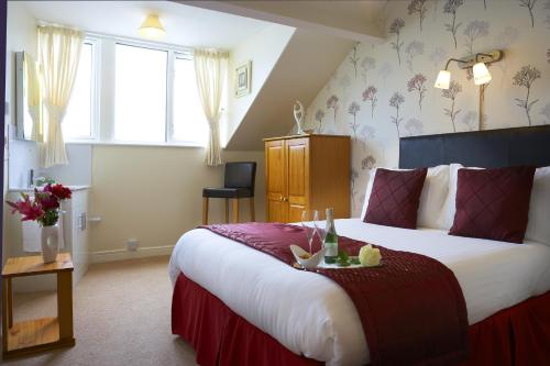 una habitación de hotel con una cama grande y flores en la pared en Howdale, en Scarborough