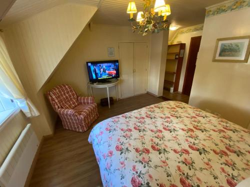 a bedroom with a bed and a tv in a room at Pousada Chateau Colinas in Campos do Jordão