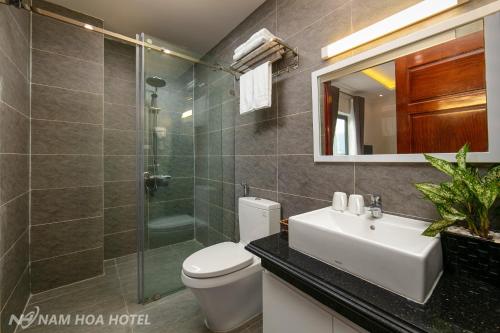 Un baño con inodoro, lavabo y ducha. en Nam Hoa Hotel, en Ninh Binh