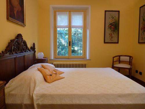 a bedroom with a large white bed with a window at Apartment Lido in Gozzano
