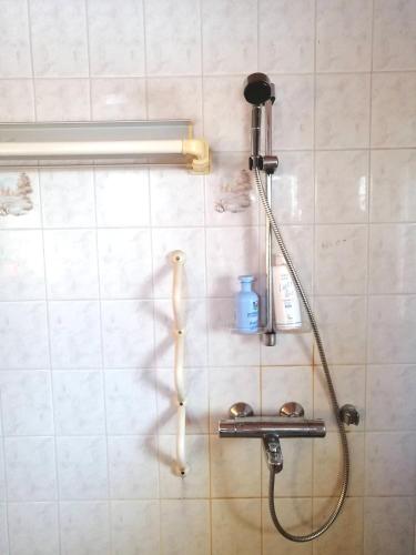 a shower with a hose on a tiled wall at Yläpihan Tila in Valtimo