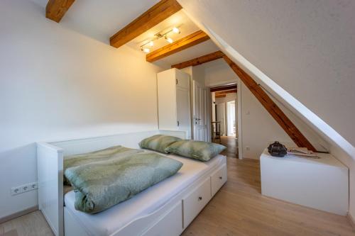 ein Schlafzimmer mit einem weißen Bett mit grünen Kissen darauf in der Unterkunft das "Ferienhaus Eibiswald" im Schilcherland in Eibiswald