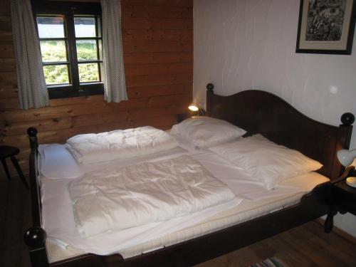 een bed met witte lakens en kussens in een slaapkamer bij Schiappartement Nassfeld in Sonnenalpe Nassfeld