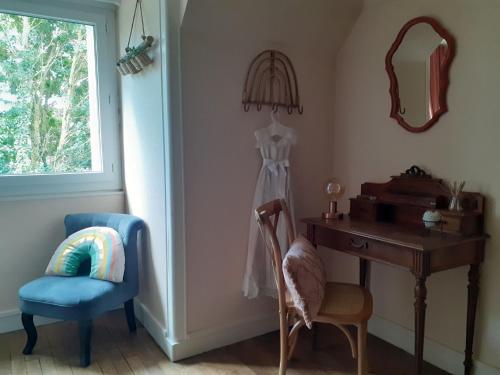 Habitación con escritorio, silla y espejo. en Le Peu'ty Cottage, en Fougères-sur-Bièvre