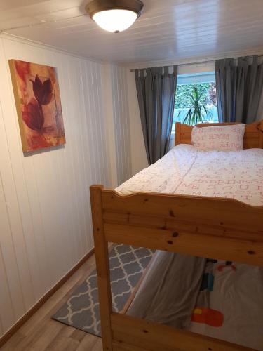 a bedroom with a wooden bunk bed with a window at apartment on the first floor of the house in Skien