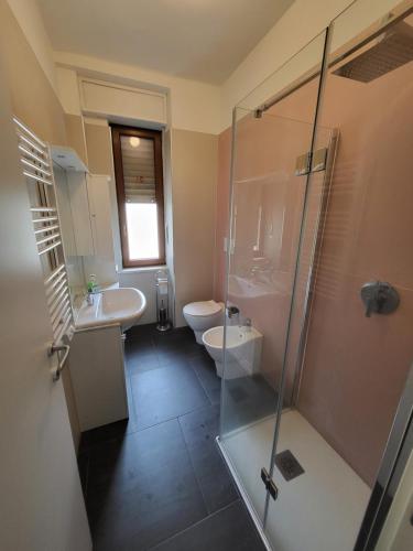 Un baño con ducha, lavabo e inodoro. en Big appartement - 9 guests - Air Conditionning and Courtyard, en Bussoleno