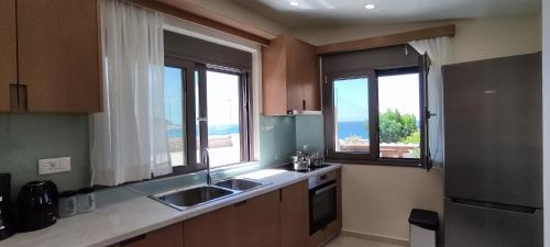 una cocina con 2 lavabos y 2 ventanas en Romantica Apartments, en Falasarna