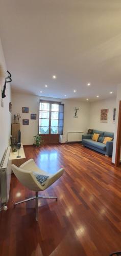 a large living room with a couch and a chair at EL MUSSOL DE LA VILA Camprodon, balconets amb vistes a la plaça in Camprodon
