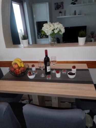 a table with a bowl of fruit and a bottle of wine at MIA in Zagreb