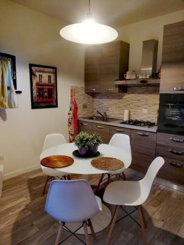 a kitchen with a white table and chairs in a room at Casolare Isabella "Il rifugio dei vinili" and Alice's room in Ponsacco