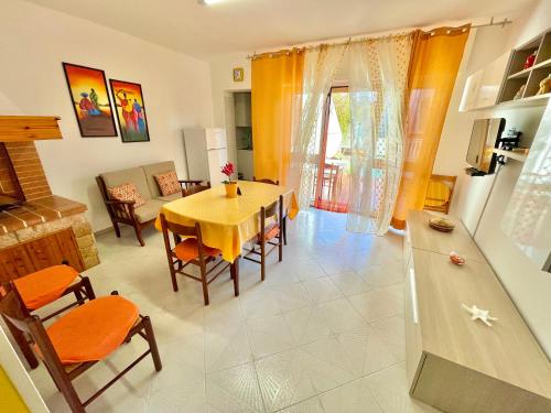 a kitchen and living room with a table and chairs at ChiarAmare Vacanza, casa con Idromassaggio, vicino Maldive del Salento in Torre Pali 