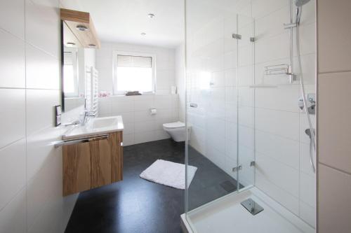 a bathroom with a shower and a sink and a toilet at Gästehaus Sonner in Dietmannsried