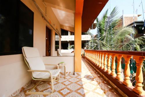 a balcony with a white chair on a porch at Cosmos @ Greenspace in Siolim