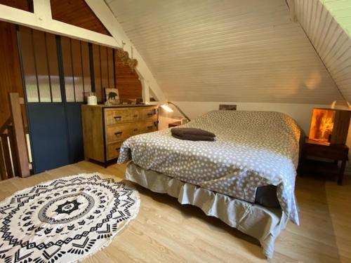 a bedroom with a bed and a rug on the floor at Gite des Trévignes in Cambremer