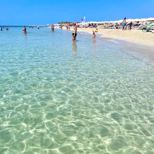 a group of people standing in the water at the beach at ChiarAmare Vacanza, casa con Idromassaggio, vicino Maldive del Salento in Torre Pali 