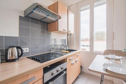 Il comprend une cuisine équipée d'une cuisinière. four supérieur à côté d'un évier dans l'établissement Joli studio