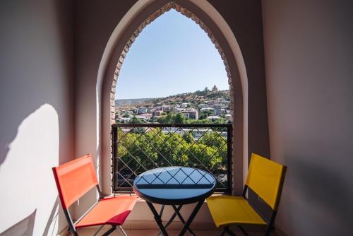Habitación con ventana con sillas y mesa. en Wine Rock Hotel, en Tiflis