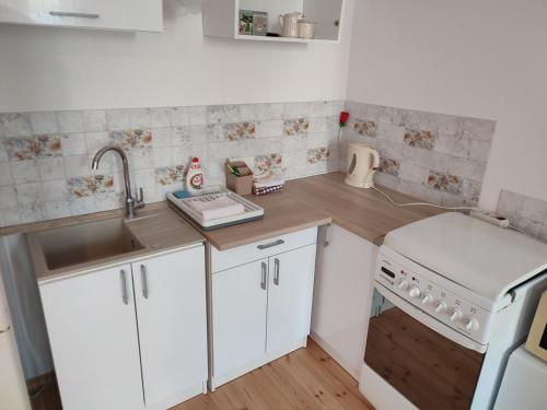 a small kitchen with white cabinets and a sink at Łapu Capu - Mieszkanie dla 4 osób in Grajewo