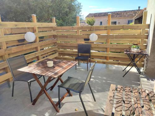 a patio with a wooden fence and a table and chairs at Studio R Homps in Homps