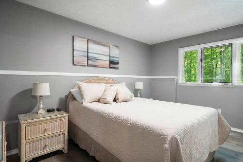 哈伯斯普林斯Harbor Springs-Secluded setting+amenities+pets的一间卧室，有一张白色的床和两扇窗户