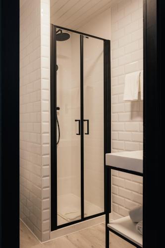 a glass shower in a bathroom with a sink at Hotel Au lit des ours in Han-sur-Lesse