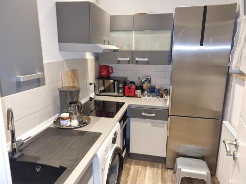 uma pequena cozinha com um frigorífico e uma máquina de lavar louça em Maria Apartment em Wolfsburg