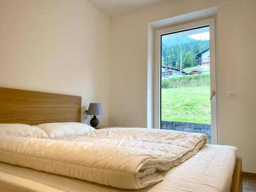 een slaapkamer met een groot bed en een raam bij Casa Scardanzan in Canale dʼAgordo