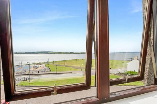 an open window with a view of the water at Penthouse Seafront Largs in Largs