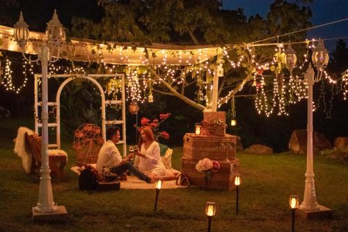 a couple sitting under a gazebo with lights at BOSQUE EL DESCANSO in Jamundí