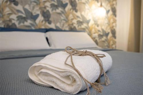 a towel on a bed with a rope on it at Car.Ma - comfy rooms in Porto SantʼElpidio