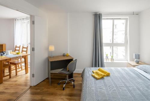 a bedroom with a bed and a desk and a chair at Comfortable and Bright Apartment in Tower Bridge in London