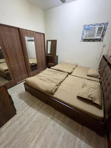 Mutrah Lux Apartment في مسقط: غرفة نوم مع سرير ومرآة على الحائط