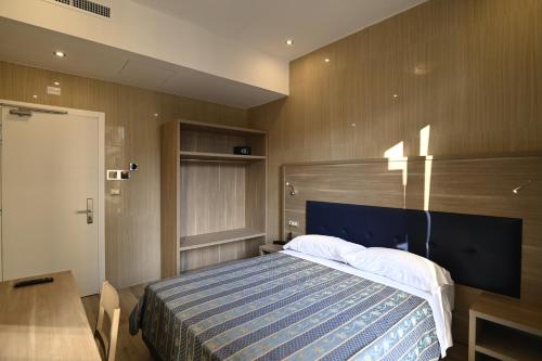 a bedroom with a bed with a blue and white blanket at Hotel Midway in Milan