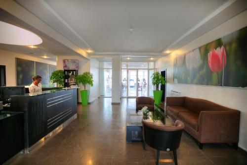 a lobby with a woman standing at a counter in a office at Casablanca Le Lido Thalasso & Spa (ex Riad Salam) in Casablanca
